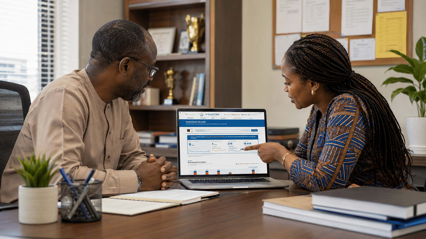 Un directeur d'établissement et une collaboratrice consultent le tableau de bord Le Grand Frère sur un ordinateur portable