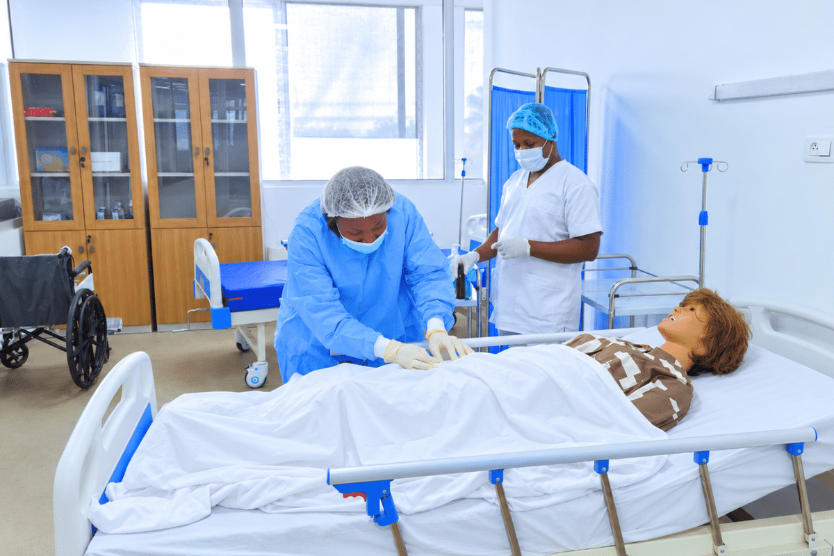 Étudiantes infirmières s'exerçant sur un mannequin de simulation médicale au laboratoire d'ISA Santé, Abidjan